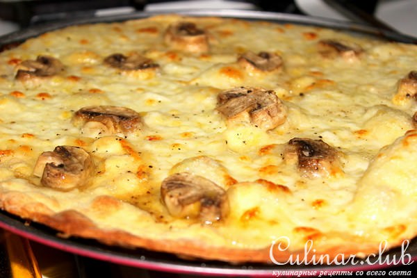 Пицца с трюфельным маслом, шампиньонами и руколой.